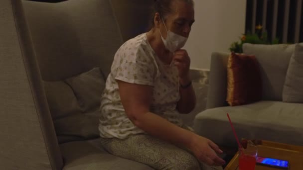 Äldre som drar ner en ansiktsmask för att svara i mobilen — Stockvideo