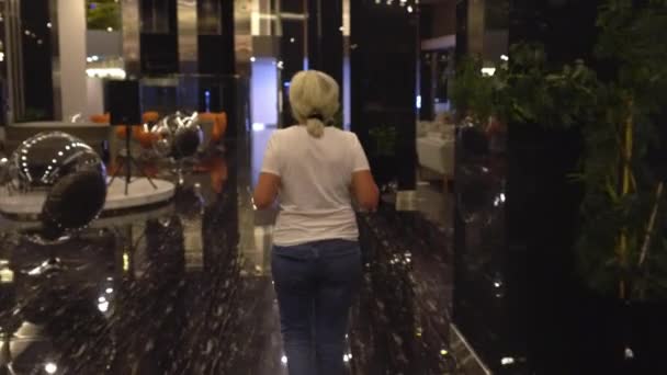 Женщина, идущая по современному вестибюлю или вестибюлю отеля — стоковое видео
