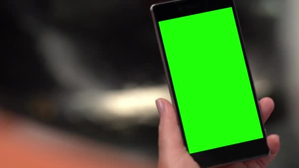 Hand holding a smartphone with a blank green screen — Stock Video