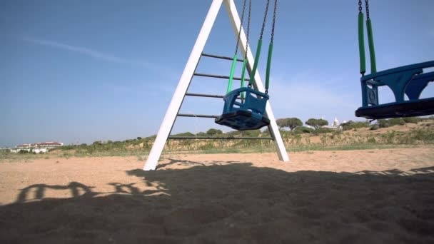 Låg vinkel syn på en A-frame swing på en sandstrand — Stockvideo