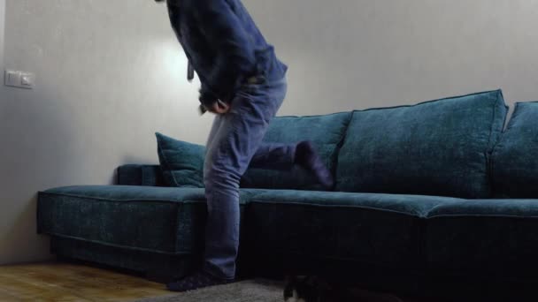 Homme en jeans et chaussettes assis sur un canapé — Video