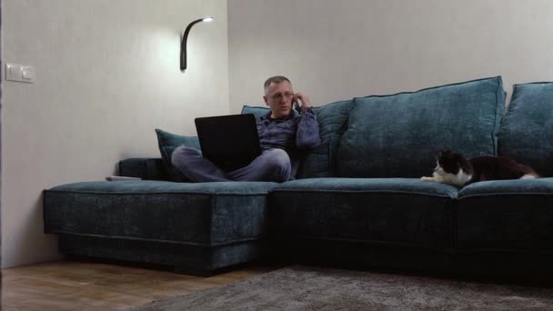 휴대 전화로 수다를 떨며 밤에 노트북으로 일하는 사람 — 비디오