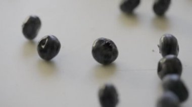 Olgun yaban mersinleri mutfak masasında ya da tezgahta zıplıyor.