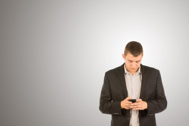 genç adam ayakta manifatura onun cep telefonu