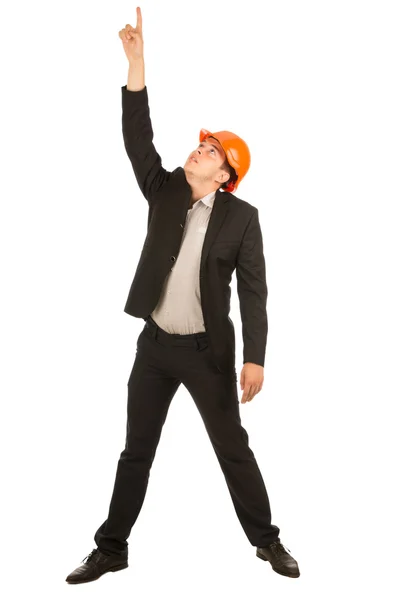 Инженер среднего возраста в оранжевом шлеме указывает вверх — стоковое фото