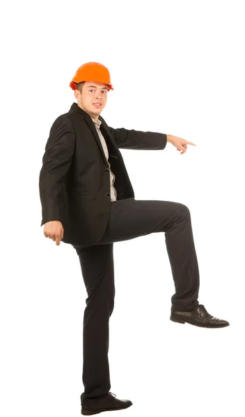 Joven ingeniero masculino levantando una pierna posando — Foto de Stock