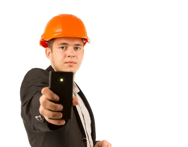 Молодой серьезный инженер держит черный мобильный телефон — стоковое фото