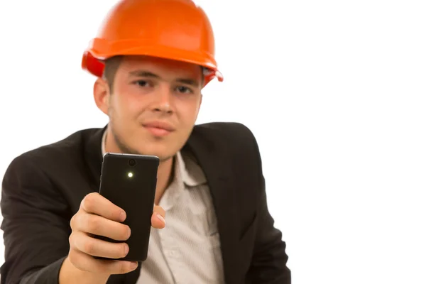 Ingenjör tittar på kameran medan du håller telefonen — Stockfoto