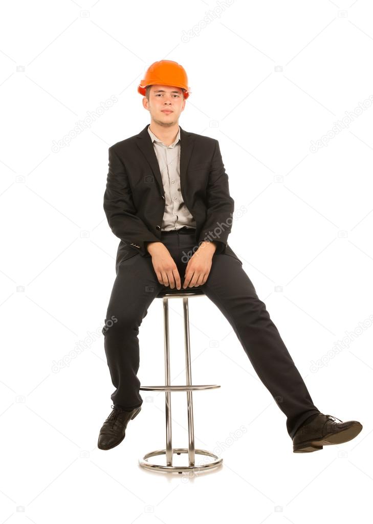 Young man in a hardhat sitting on a bar stool — Stock Photo