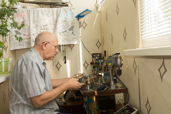 Homme à la retraite travaillant à la maison sur son artisanat — Photo