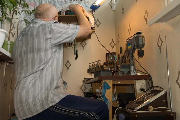 Senior man aan het werk op een werkbank — Stockfoto