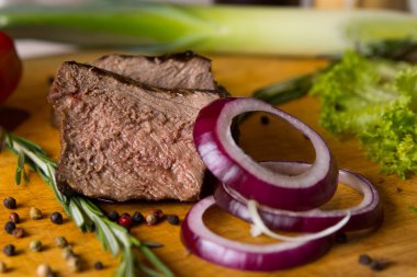 sığır eti ve doğrama kurulu üzerinde kırmızı soğan dilimlenmiş