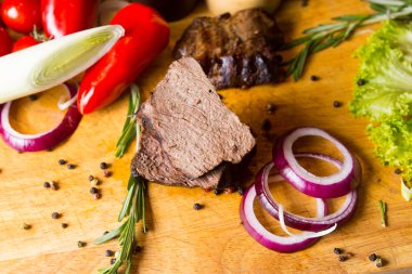 dilimlenmiş Dana eti ve sebze kesme tahtası üzerinde