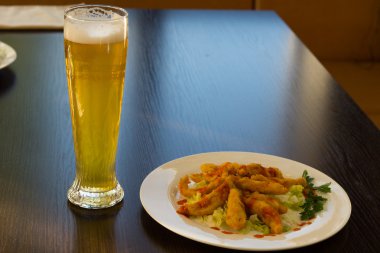 Fried Main Dish on White Plate and Glass of Beer clipart