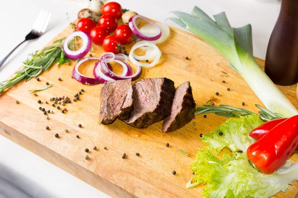 Lekkere gegrilde mals vlees segmenten op houten bord — Stockfoto