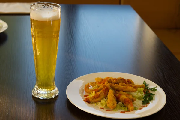 Prato principal frito na placa branca e vidro de cerveja — Fotografia de Stock