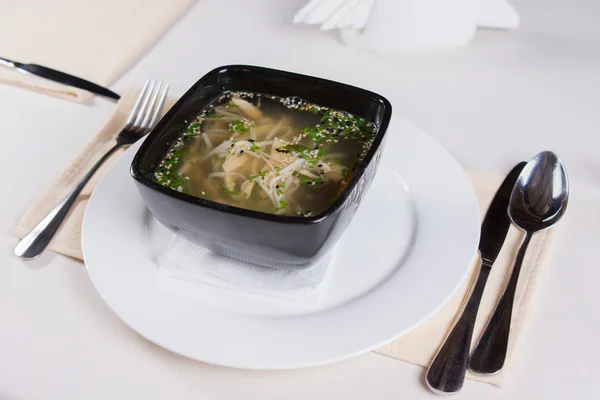 Smakelijk soep op zwarte bowl geserveerd op plaat — Stockfoto