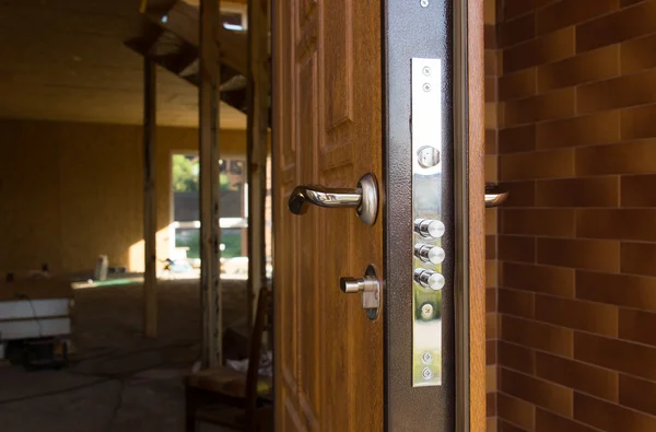 Safety lock on a new wooden front door — Stock Photo, Image