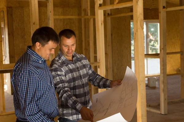 Dois construtores dentro de uma casa meio concluída — Fotografia de Stock
