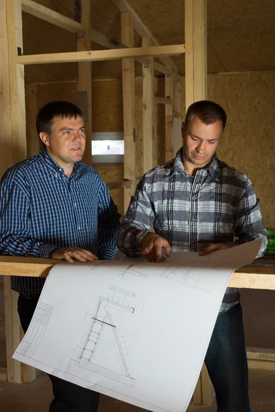 Zwei Bauarbeiter prüfen gemeinsam einen Bauplan — Stockfoto
