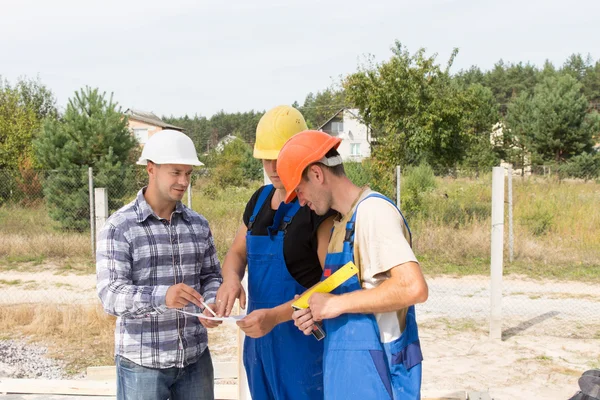 Engenheiro discutindo especificações com trabalhadores — Fotografia de Stock