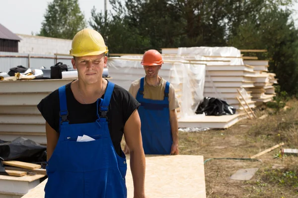 Lavoratori edili che trasportano pannelli murali — Foto Stock