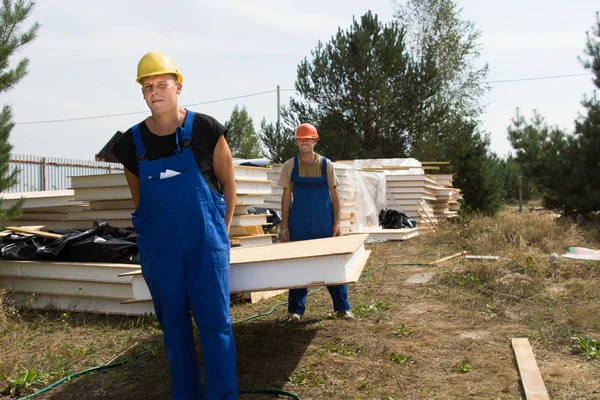 Les travailleurs de la construction portent un panneau d'isolation murale — Photo