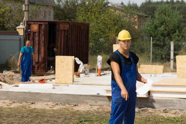 Workman wijst naar iets op de grond — Stockfoto