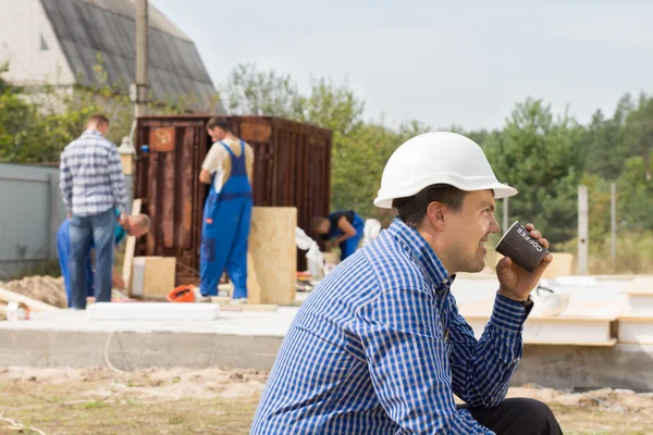 Workman, pití kávy na staveniště — Stock fotografie