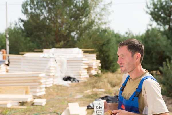 Jonge bouwer genieten van een koffiepauze — Stockfoto