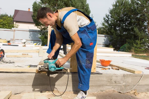 Carpenter sanding a wood beam on site — Stock Photo, Image