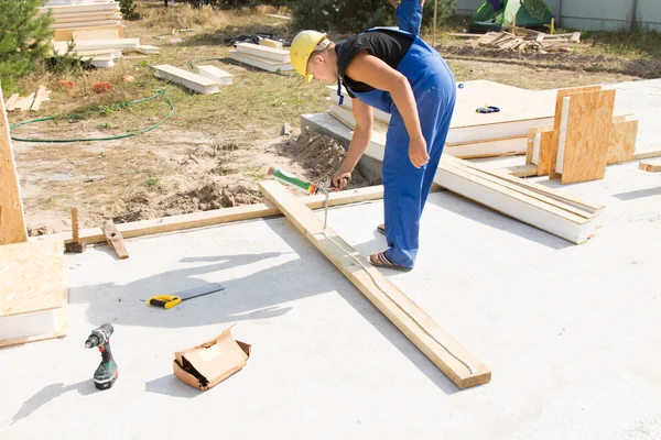 Workman applying glue to an insulated beam — Stock Photo, Image