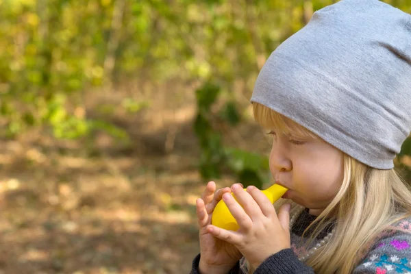 Jovem menina soprando brinquedo balão amarelo — Fotografia de Stock