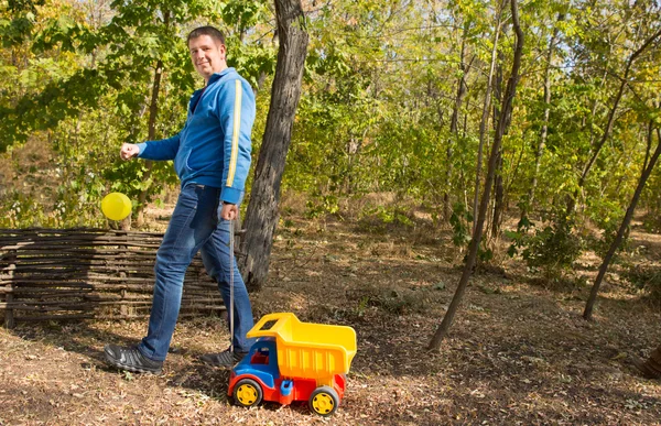 Homem de meia idade jogando caminhão brinquedo — Fotografia de Stock