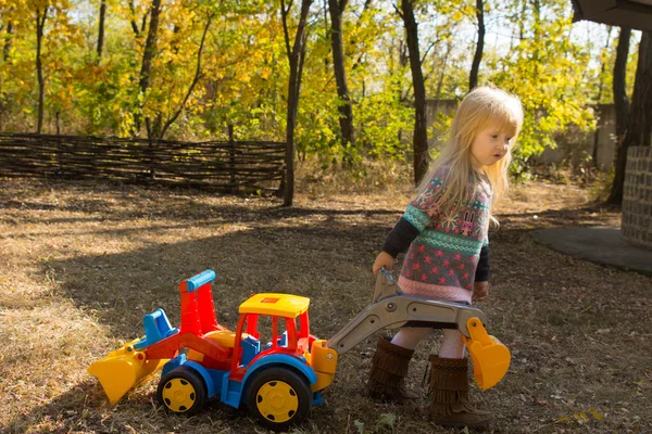 Menina com um veículo de construção de brinquedo — Fotografia de Stock