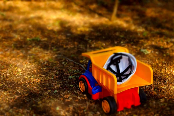 Hardhat na parte de trás de um caminhão de lixo de brinquedo — Fotografia de Stock