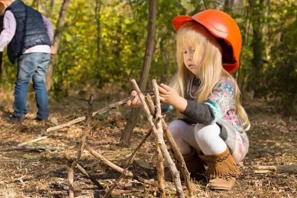 Cute little blond girl in an oversized hardhat — Stock Photo, Image