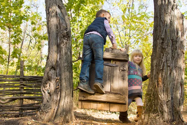 Kleine jongen en meisje spelen op een oude poort — Stockfoto