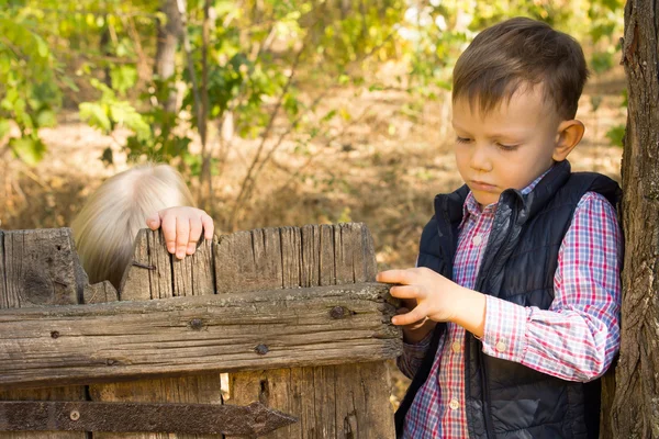 Little boy opening an old wooden gate — Stock Photo, Image