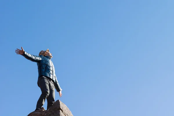 Jeune homme exubérant sur un vieux mur de pierre — Photo