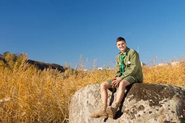 Boy scout su grande roccia a il campo zona — Foto Stock