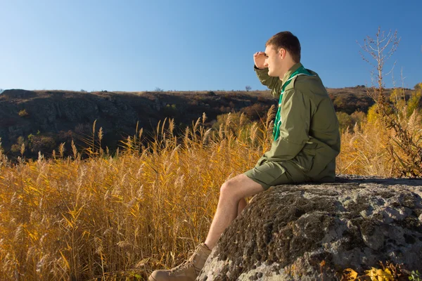 Unga Boy Scout på Rock tittar brett fält — Stockfoto