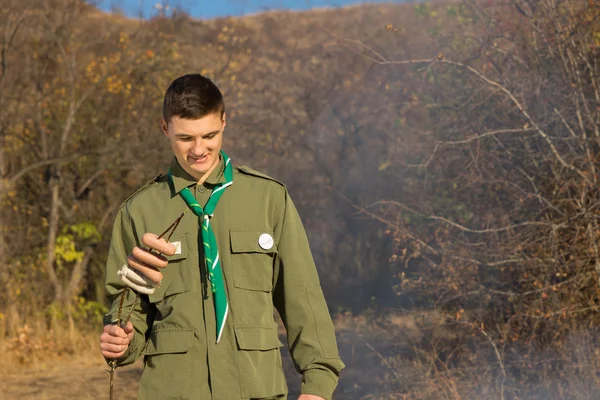 Scout preparándose para cocinar salchichas en un fuego — Foto de Stock