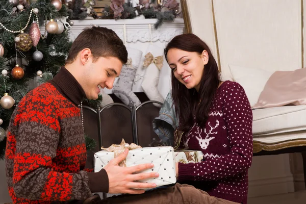 Çift hediyeler Noel ağacı yakınındaki ile gülümseyen — Stok fotoğraf