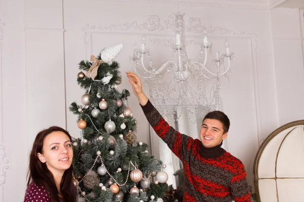 Uśmiechnięta młoda para dekoracji na Boże Narodzenie — Zdjęcie stockowe
