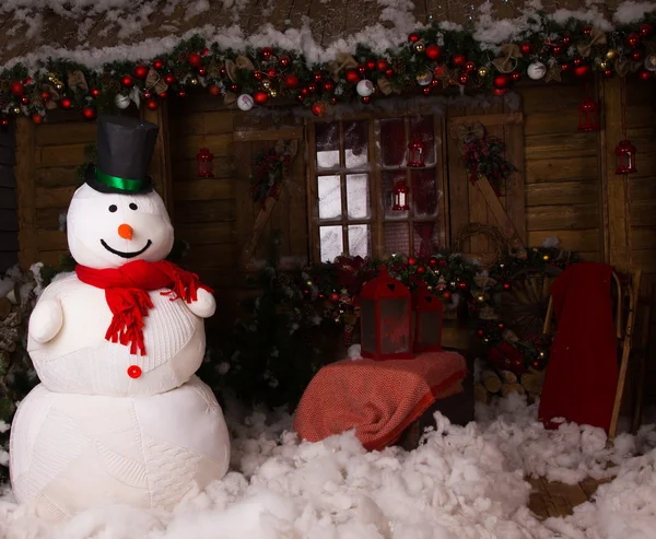 Grote Winter Snowman op versierde houten huis — Stockfoto