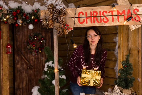 Mladá žena držící dárky na Vánoce stánku — Stock fotografie