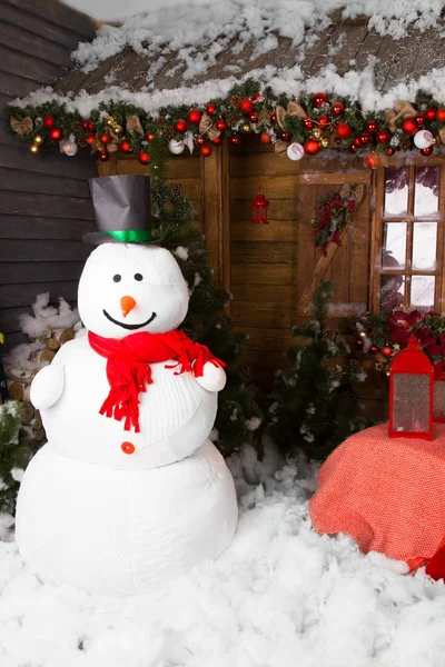 Muñeco de nieve de invierno rodeado de decoraciones navideñas —  Fotos de Stock