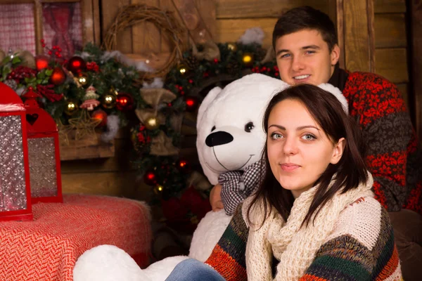 Casal sentado em roupa de inverno com boneca de urso — Fotografia de Stock