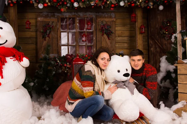 Jovem casal abraçando branco urso de inverno boneca — Fotografia de Stock